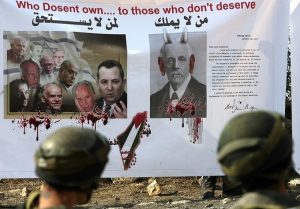 Israeli soldiers in front of a banner with a protesting against balfour (AFP)